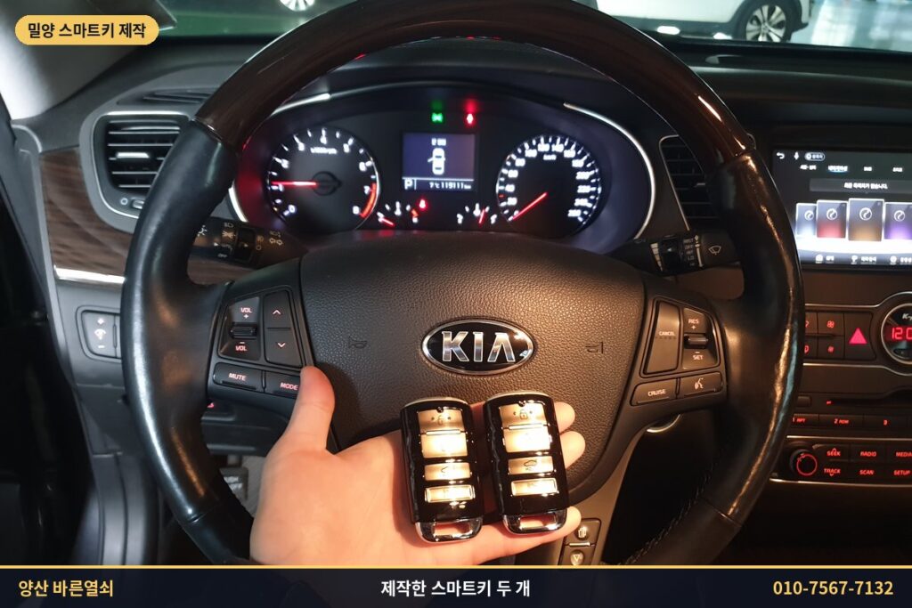 운전석에서 제작한 K7 스마트키 두 개를 든 모습